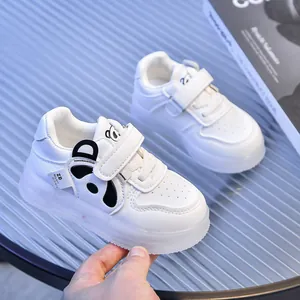 Close-up of white toddler sneakers featuring cute panda icons and thick rubber soles