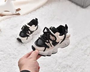 Detail of warm black and white kids sneakers with fleece lining and thick wavy soles