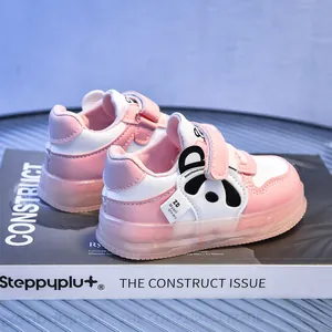 Close-up of pink and white baby sneakers with panda design and velcro straps
