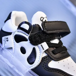 Detailed macro view of panda-themed toddler shoes with velcro strap and leather texture