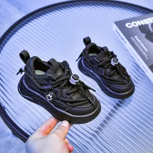 Détail de baskets noires pour enfants avec logo smiley et semelle épaisse antidérapante