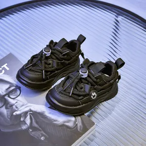 Détail de baskets noires pour enfants avec tige en mesh, semelle épaisse et smiley