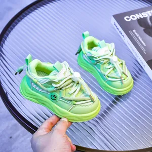 Détail d'une basket enfant en mesh respirant vert fluo avec icône smiley jaune