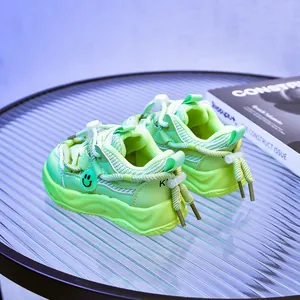Détail de baskets enfants vert fluo en mesh respirant avec pendentif smiley