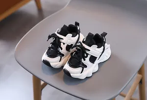 Detail of kids black and white chunky sneaker with mesh panels and velcro strap