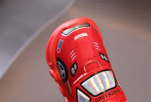 Detail shot of a red racing car themed toddler shoe with SHOCK LIGHT text and metallic finish