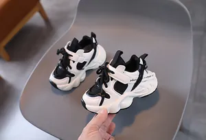 Detailed view of kids' black and white chunky sneakers with plush lining and velcro strap