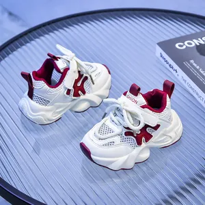 Dettaglio di scarpe sportive per bambini bianche e rosse con mesh traspirante e cinturino velcro