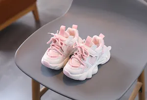 Detailed view of pink and beige kids sneakers with warm fleece lining and thick wavy soles