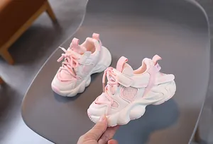 Detail of pink and white kids' sneakers with plush lining and non-slip rubber soles