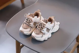 Detail view of children's thick-soled sneakers with beige faux leather and mesh panels