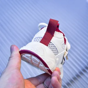 Dettaglio del tessuto a rete traspirante e suola antiscivolo per scarpe sportive per bambini