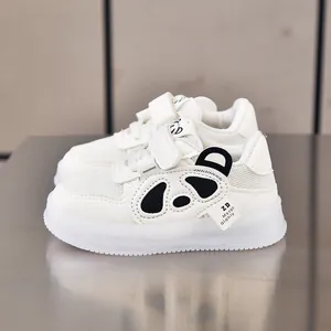 Detail of white toddler sneaker featuring cute panda design and adjustable velcro strap