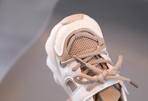Detail of warm kids sports sneakers showing cream and brown leather mesh texture