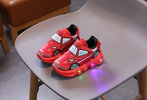Detail of red car-shaped kids sneakers showing LED lights and velcro closure