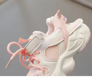 Close-up of pink and beige kids sneakers showing breathable mesh and wave foam sole