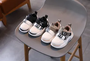 Close-up of kids leather sneakers featuring double buckle straps and durable rubber soles