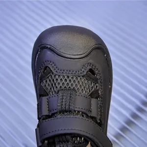 Close-up of black mesh kids sandals with reinforced toe cap and velcro strap