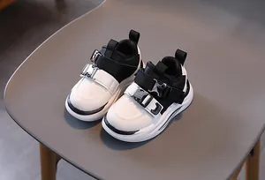 Top-down view of kids sneakers featuring industrial buckle straps and thick white soles