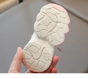 Detailed macro view of the anti-slip cream rubber sole with size 23 mark for kids shoes