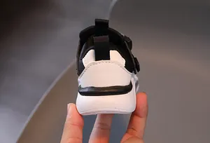 Detail view of children's sneaker heel with black pull tab and thick white rubber sole