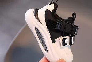Close-up of children's sneaker with leather upper, velcro strap, and cushioned sole