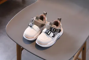 Detail view of children sports shoes featuring double buckle straps and thick rubber soles