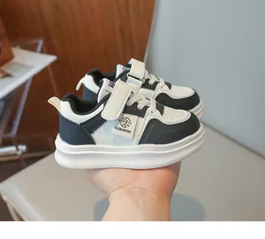 Détail de baskets en cuir pour enfants noir et blanc avec fermeture à scratch pratique