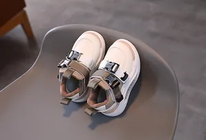 Close-up of kids leather sneakers with double metallic buckle straps and heel pull tab