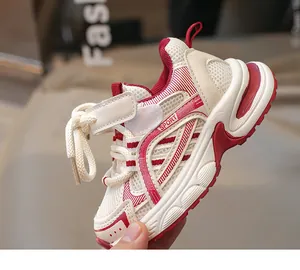 Détail de baskets respirantes pour enfants avec scratch et touches de cuir rouge sportif