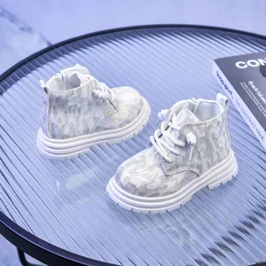 Détail de bottines argentées pailletées pour enfants avec semelles blanches antidérapantes