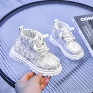 Détail de bottes pour enfants avec paillettes argentées, fermeture éclair et semelle