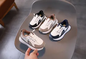 Détail de baskets chunky pour enfants en couleurs blanc, noir, marron et bleu
