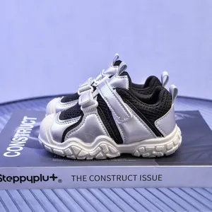 Detalle de zapatillas infantiles en plata y negro con doble velcro y suela gruesa blanca