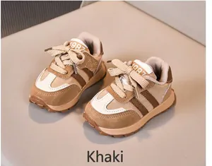 Nahaufnahme von khakifarbenen Retro-Kindersportschuhen mit 1987-Stickerei und Antirutschsohle