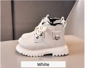 Detail of white kids' leather boots showing textured upper, round pouch, and thick rubber sole