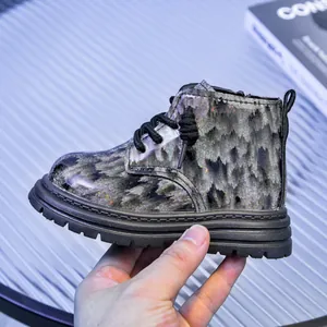 Détail de bottines Martin pour enfants avec texture pailletée argentée et zip latéral