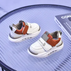 Dettaglio delle sneakers per bambini bianche e arancioni con chiusura in velcro