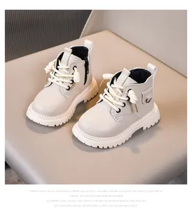 Close-up of children's beige leather boots showing soft sole and side zipper details