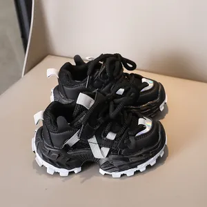 Detailansicht schwarzer Kinder-Sneaker mit rutschfester dicker Sohle und Glanzeffekten