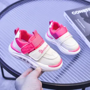 Dettaglio di scarpe luminose rosa e bianche per bambini con doppia chiusura velcro