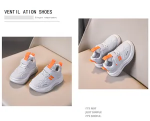 Detail of white and orange kids sneakers with velcro straps and breathable mesh