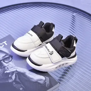 Dettaglio di sneaker per bambini con inserti in pelle bianca e chiusura con velcro