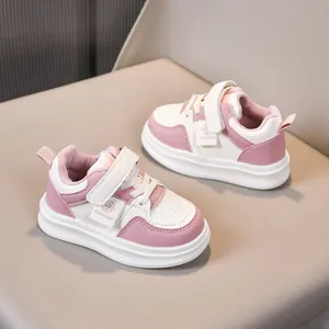 Detail view of pink and white kids' fleece sneakers with Velcro straps and thick soles
