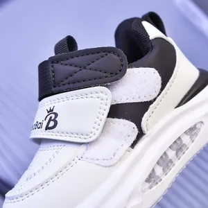 Dettaglio di scarpe LED per bambini in pelle bianca e nera con chiusura a strappo