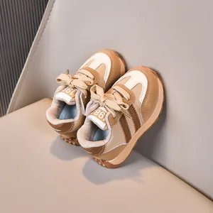 Detail der Retro Kinder Sportschuhe in Beige und Braun mit 1987 Etikett und Gummisohle