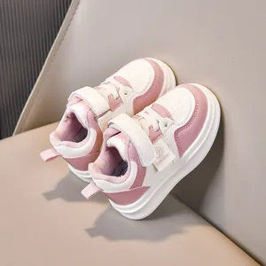 Detail view of pink and white toddler sneakers with velcro straps and soft lining