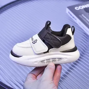 Dettaglio di scarpe LED per bambini bianco e nero con strappo e suola spessa