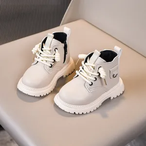 Detailed close-up of cream children's boots with non-slip thick sole and side zipper