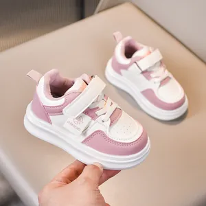 Detail view of pink and white kids' leather sneakers with fleece lining and velcro straps